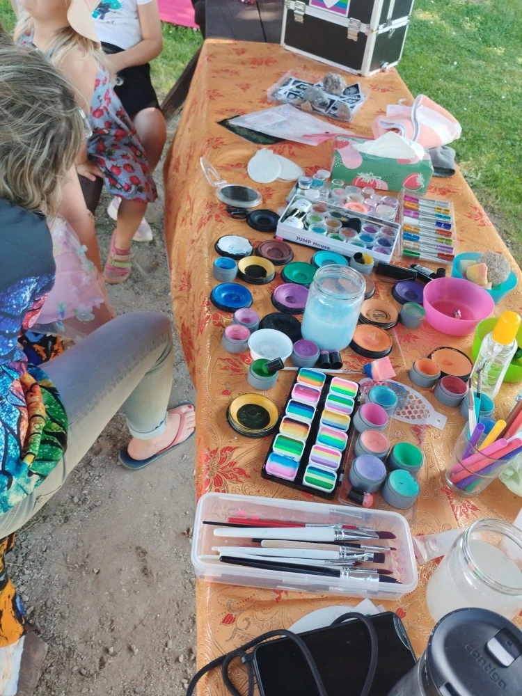 Basteltisch mit Material und die bunte Schminkstation